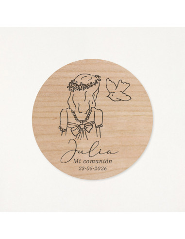 Imán de madera circular grabado con la ilustración de una niña y una paloma como recordatorio de su primera comunión