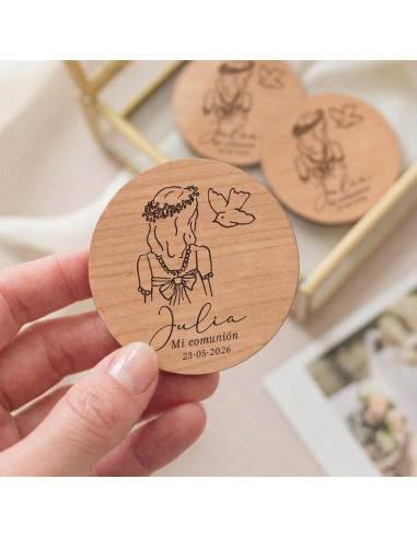 Imán de madera circular grabado con la ilustración de una niña y una paloma como recordatorio de su primera comunión
