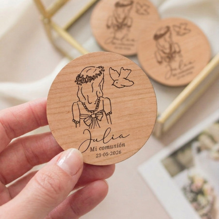 Imán de madera circular grabado con la ilustración de una niña y una paloma como recordatorio de su primera comunión