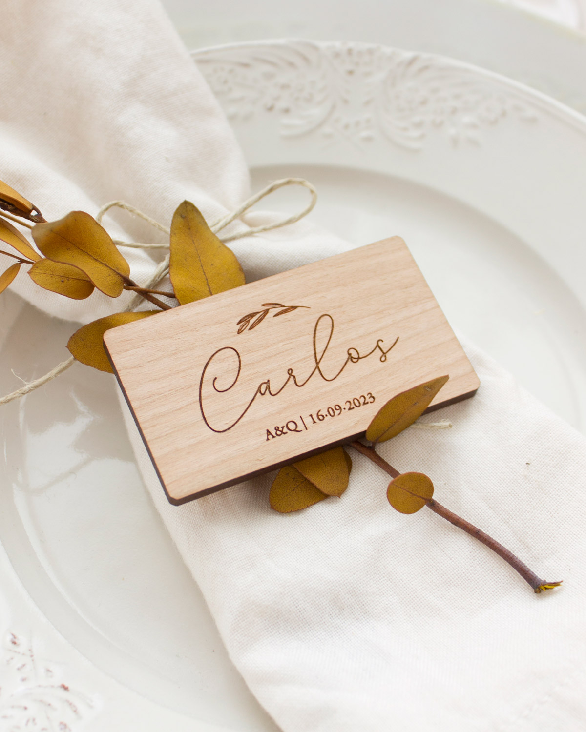 Imán rectangular con el nombre Carlos sobre el plato de un invitado de boda