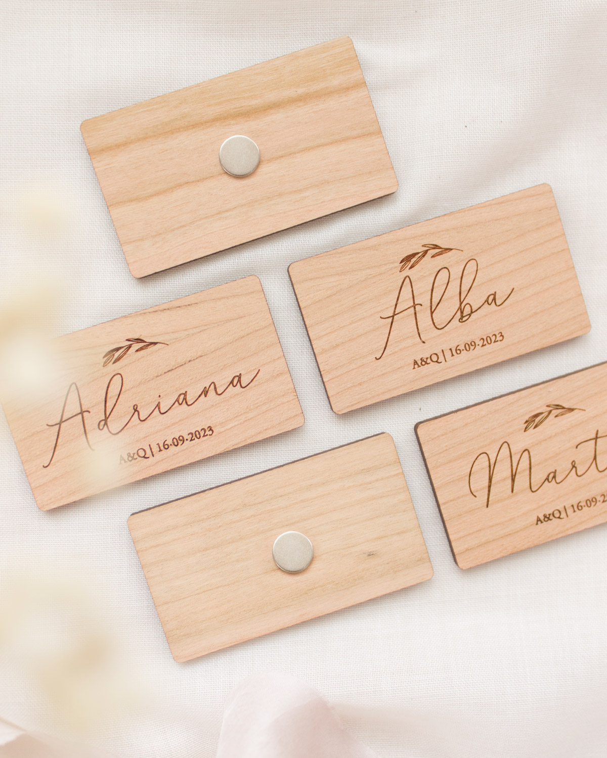Imanes rectangulares de madera con el nombre de cada invitado