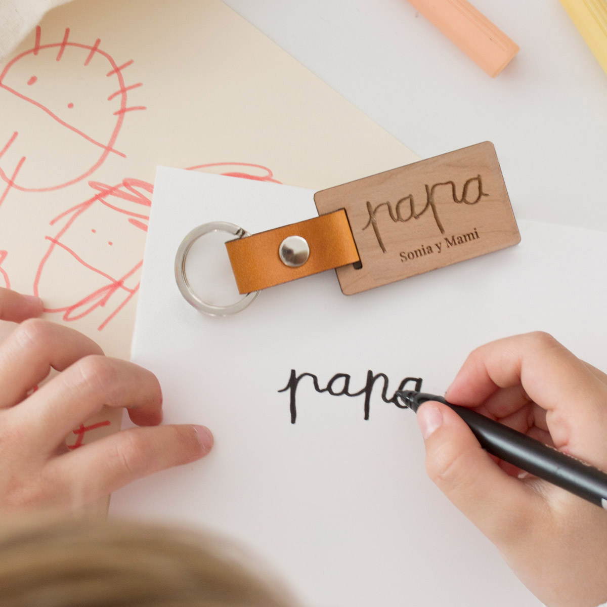 Llavero de madera grabado con la palabra papa escrita por un niño o niña