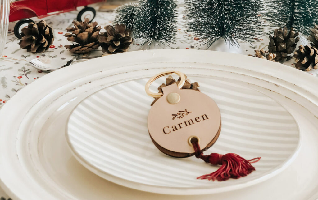 Llavero de cuero con nombre grabado sobre un plato en mesa de Navidad