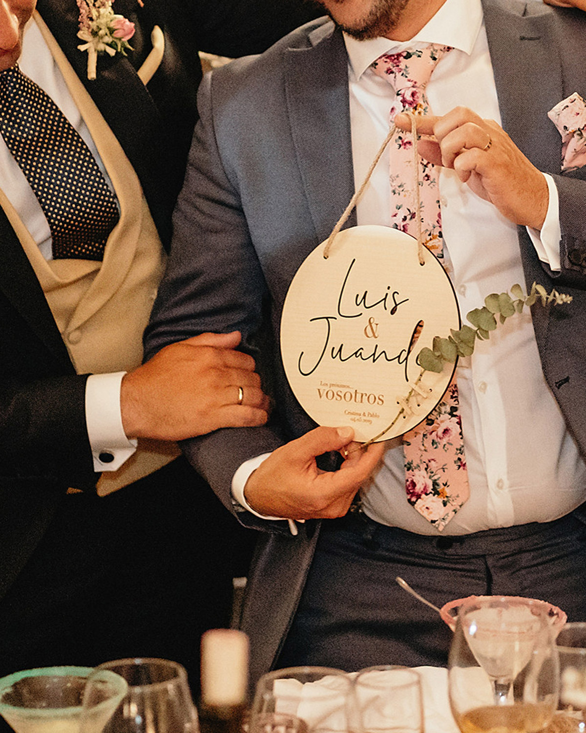 Pareja sorprendida y feliz al recibir una placa personalizada en la boda de sus amigos