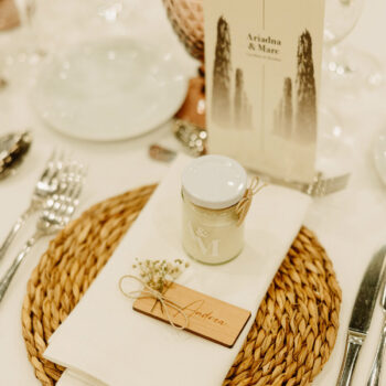 Velas de cristal personalizadas con el logo de la boda de Ari y Marc, creando un ambiente mágico en el comedor.