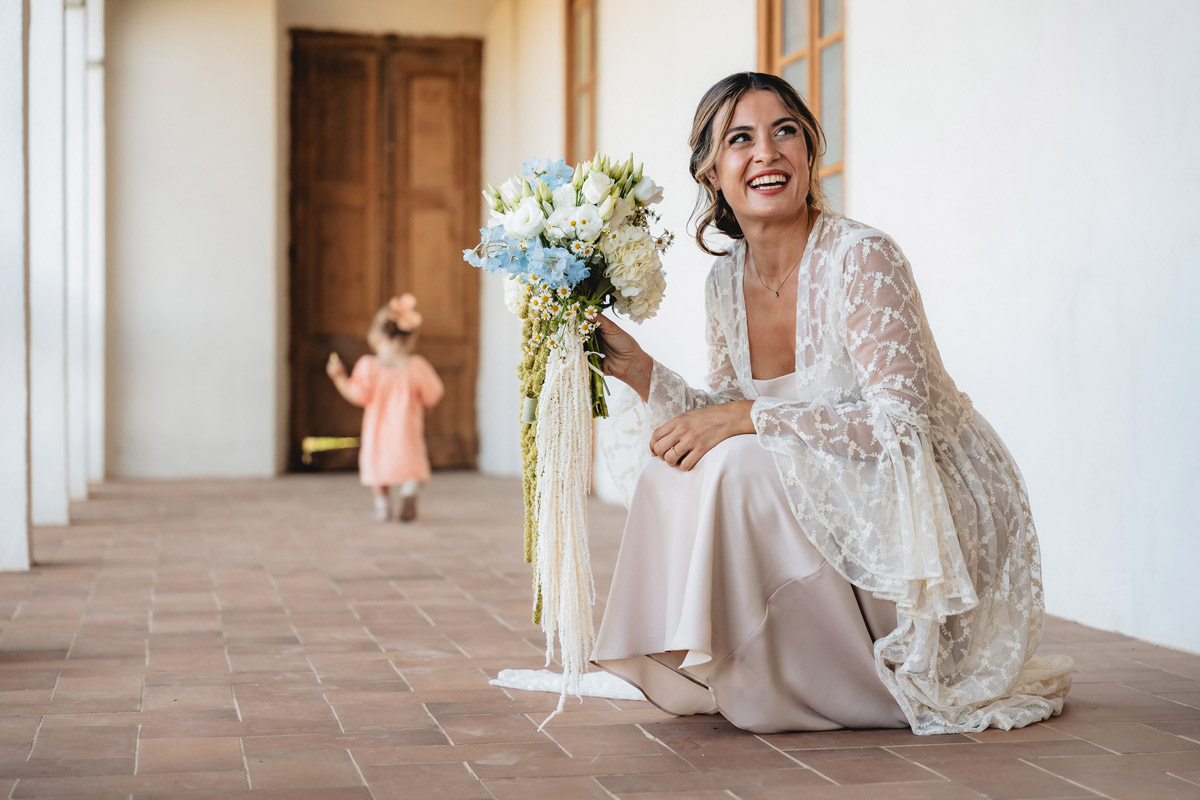 novia vestida con ramo de flores azules y blancas