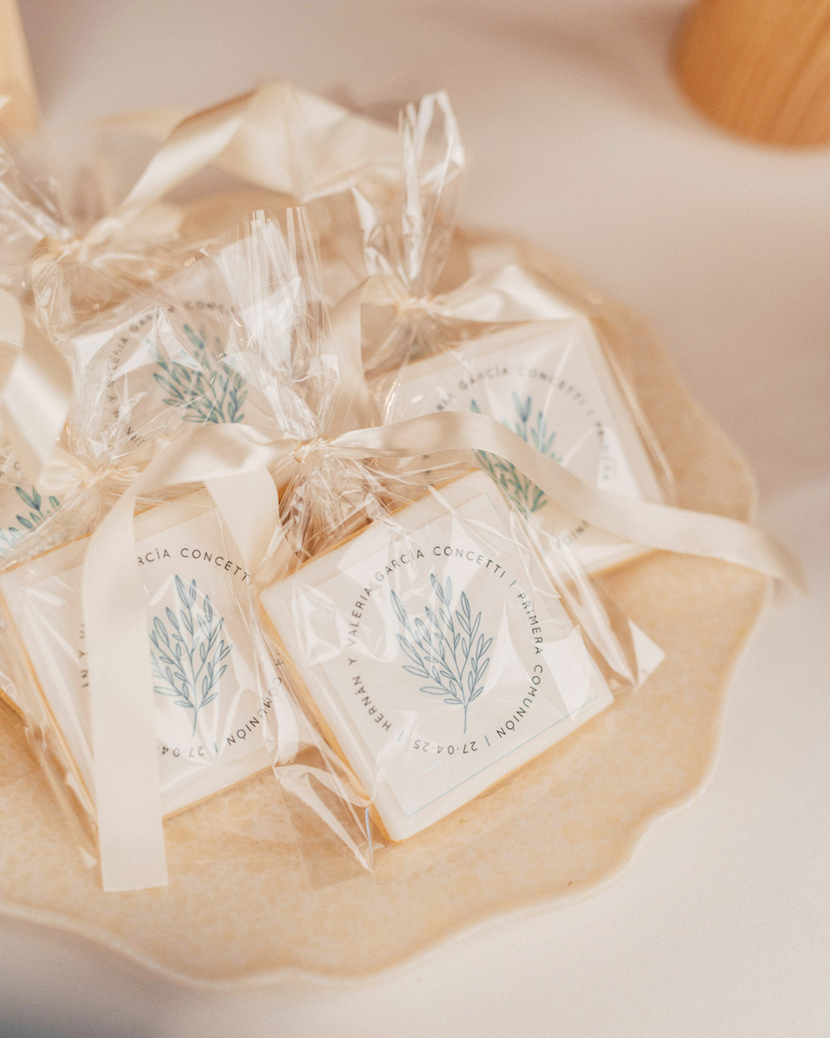 Galletas decoradas con logo floral Ramillete, presentadas en bolsitas transparentes y lazo azul
