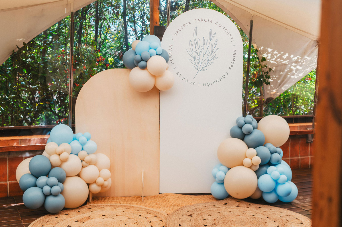 Photocall con logotipo botánico Ramillete en fondo de tela, globos blancos y azules