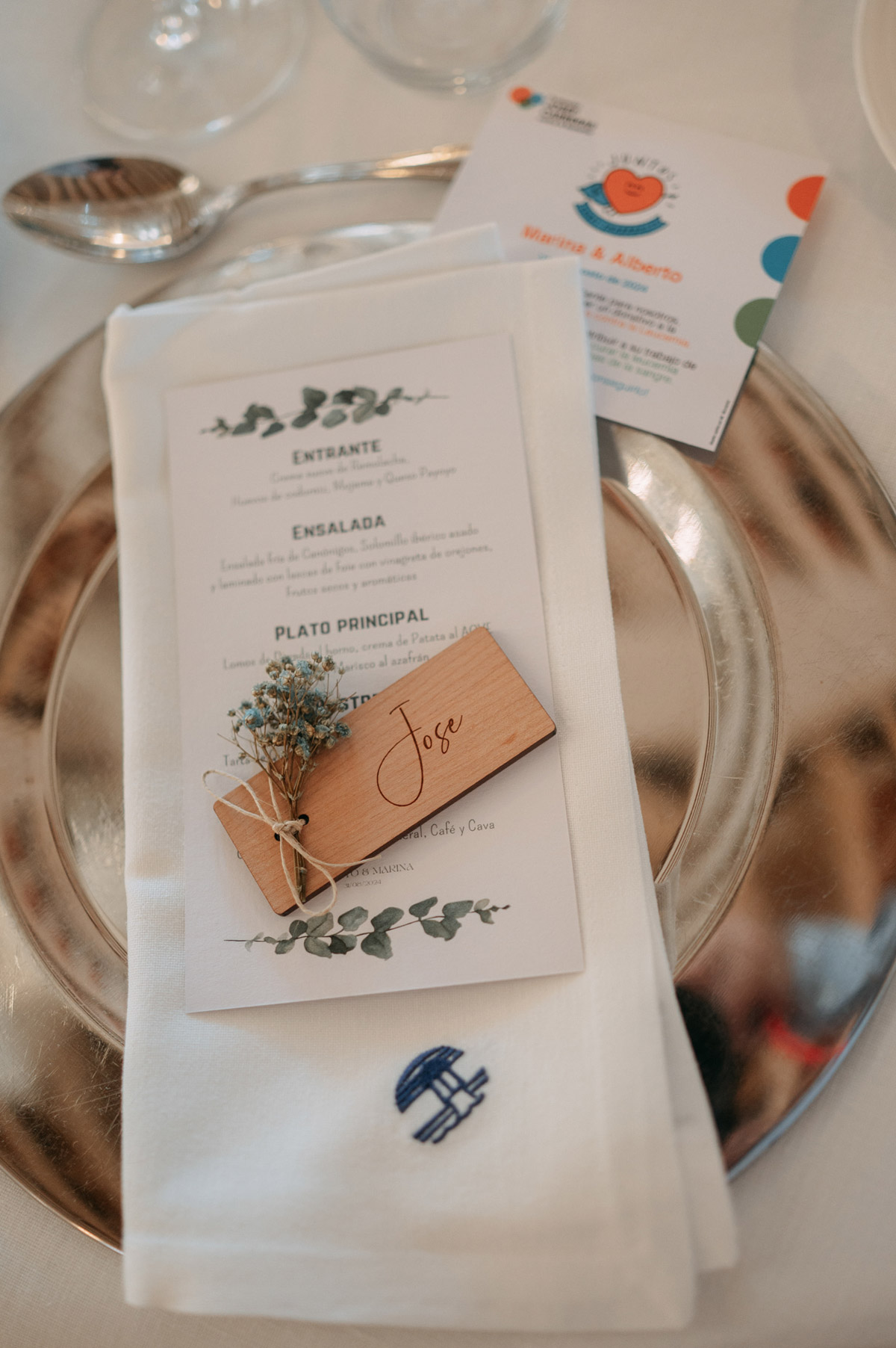 Detalle del plato con marcasitios personalizado y flores para invitados