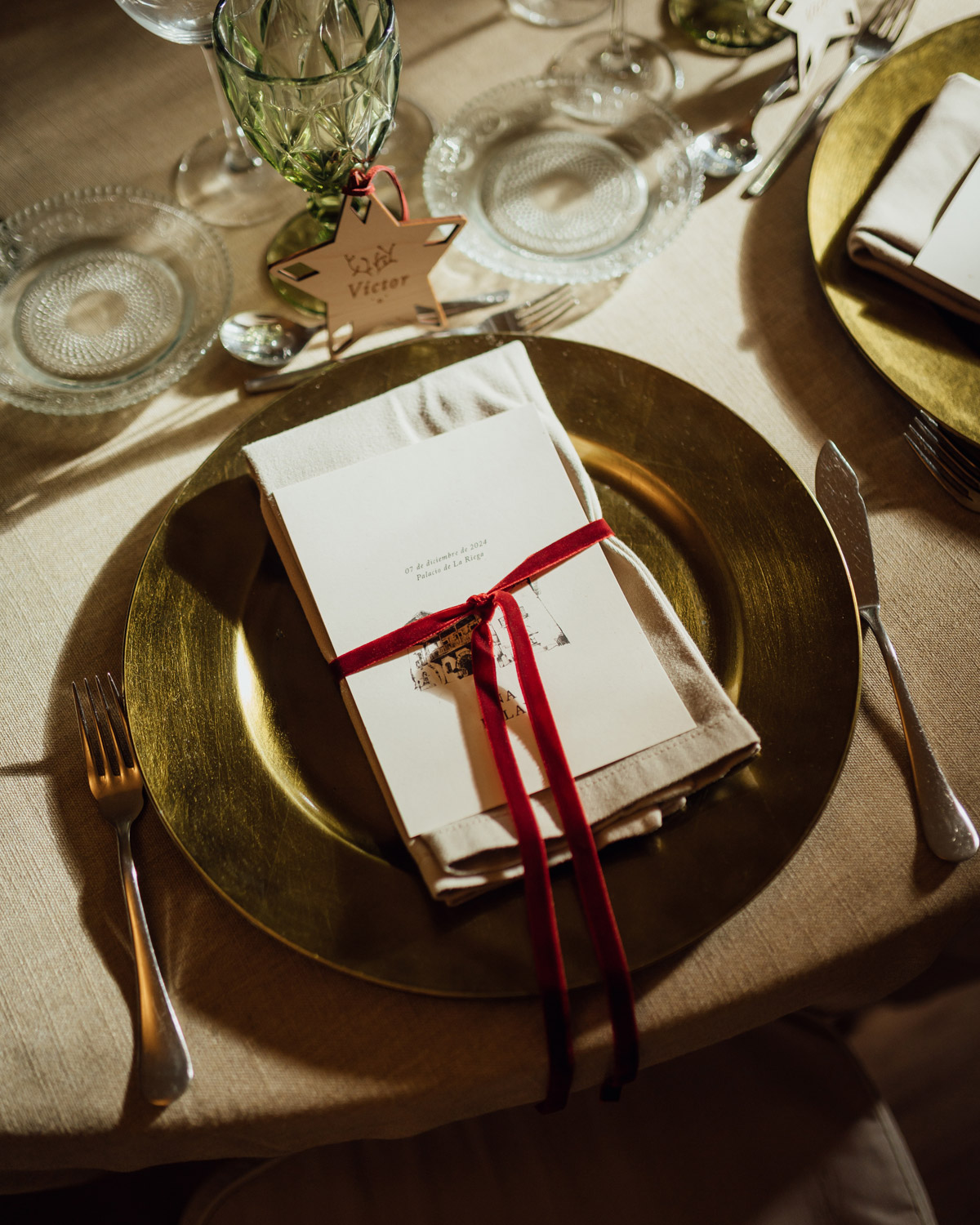 Minuta en una mesa de boda decorada con un lazo rojo en terciopelo